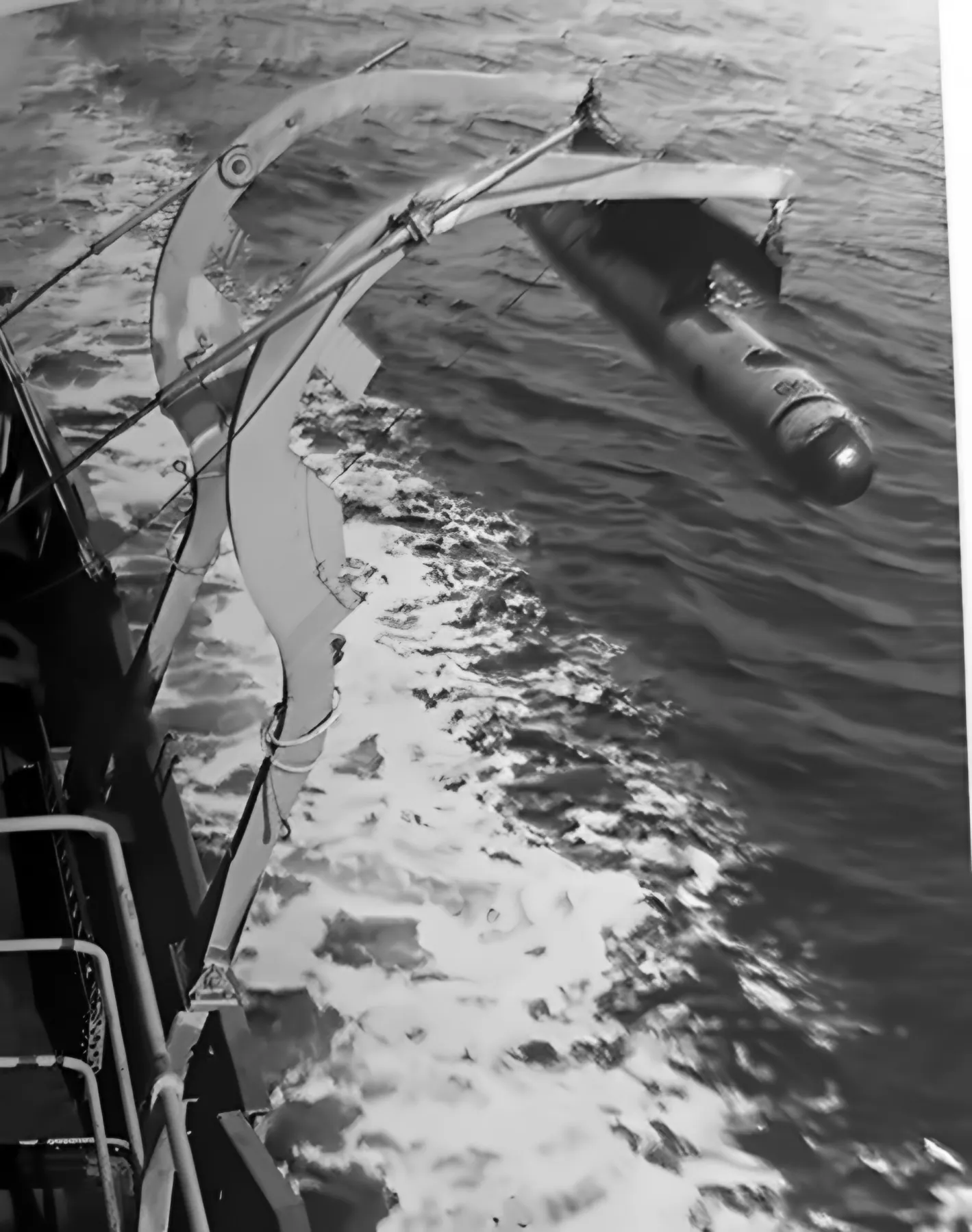 Torpeda zwisa na żurawiku nad kilwaterem łodzi