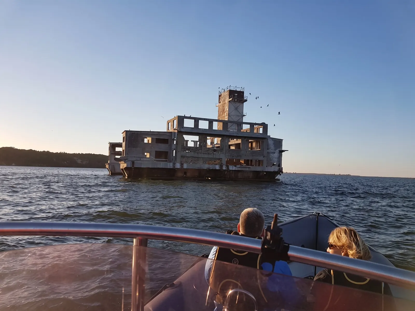Ruina torpedowni z wieżą, na pierwszym planie pasażerowie łodzi RIB